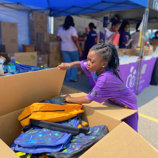 A young child volunteer from The Shidaa Foundation, smiling while helping